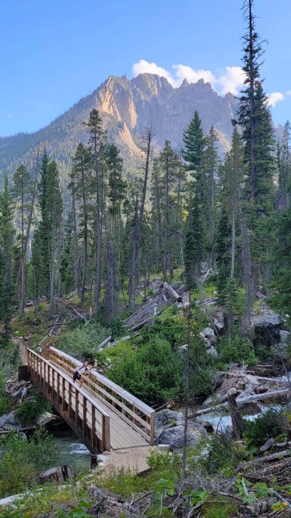 a bridge over a creek with a majestic alpine view in the sawtooth mountains of Idaho