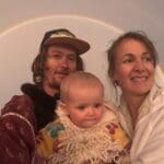 a family posing in front of a magnificent rainbow at burning man