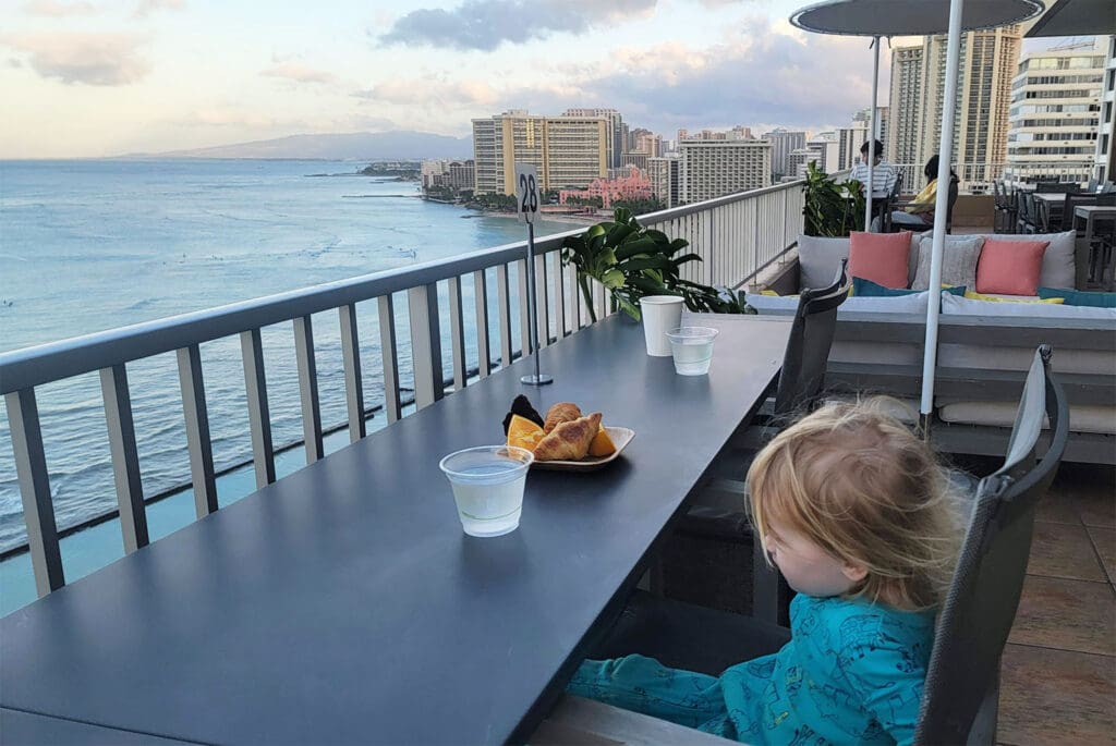 a toddler looks out at the view of the pacific ocean in waikiki, hawaii
