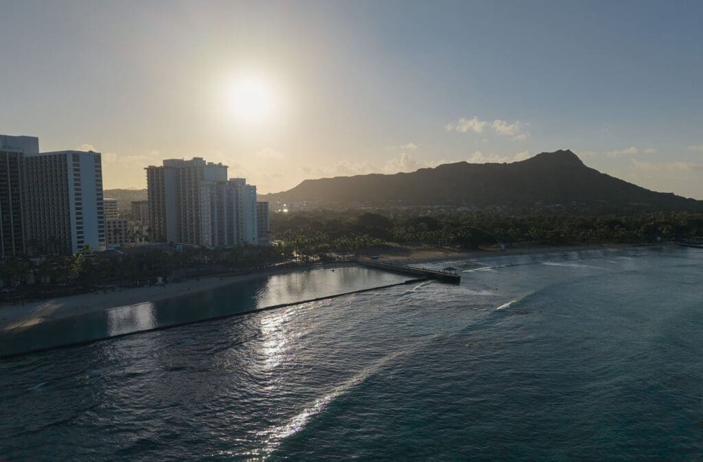 a view of waikiki beach and diamond head from the air at sunrise