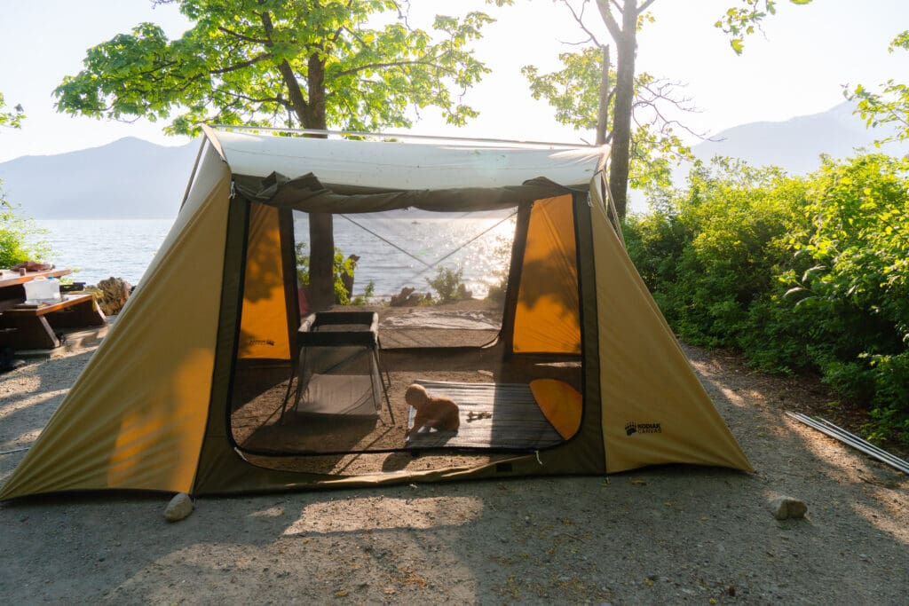 a baby plays inside a kodiak utility tent
