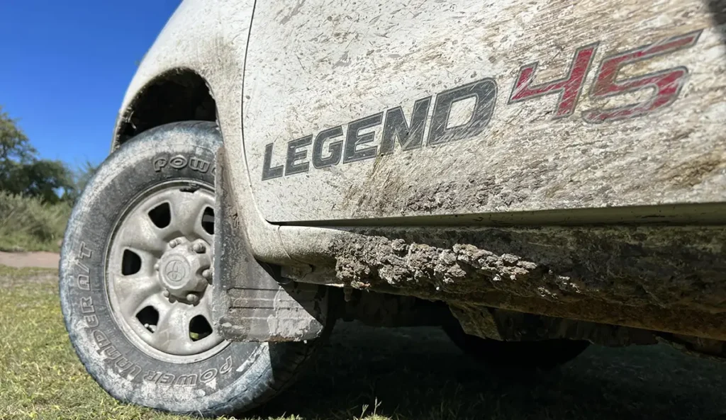 the driver's side of a muddy 4x4 vehicle while overlanding through africa