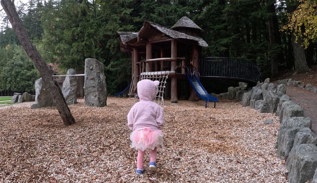 a child walks up to the play structure at alpha lake park in whistler, bc