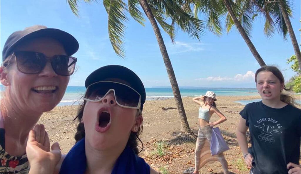 A family of four poses with silly faces on the beach in Costa rica