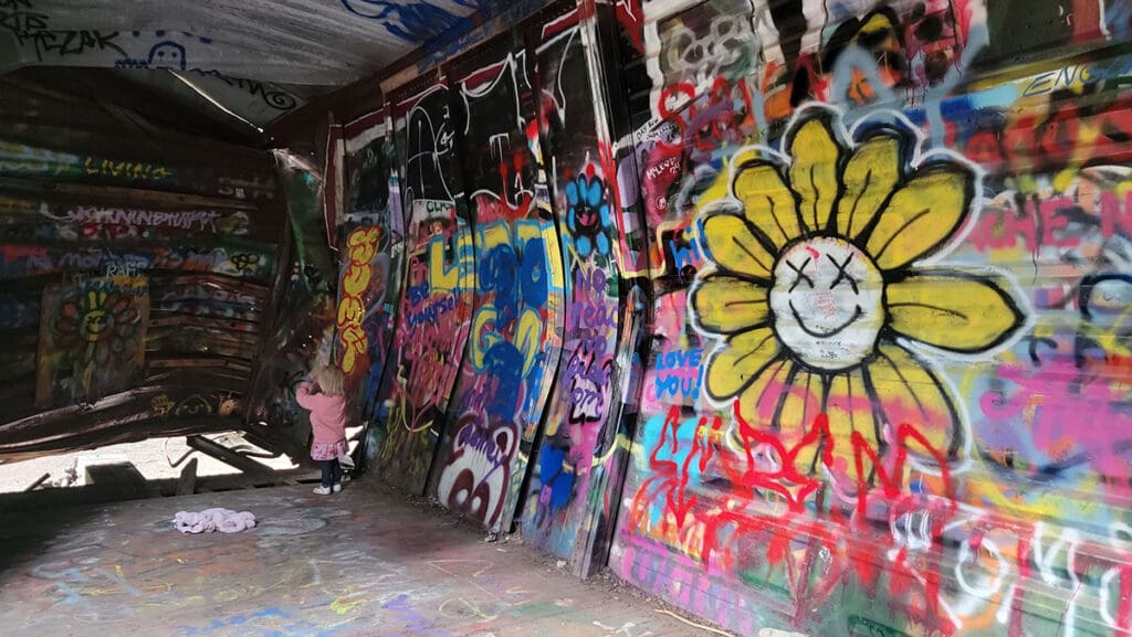 a child explores the inside of one of the abandoned train cars in on the train wreck trail in whistler