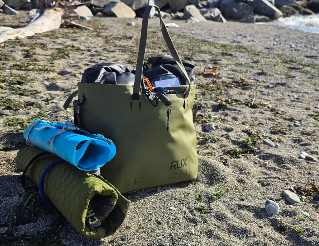 a green RUX waterproof bag fully packed for our test of the best beach totes.