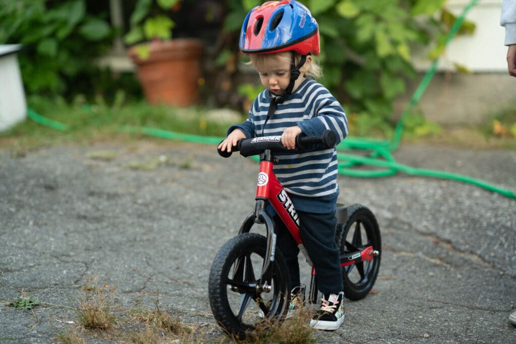 a young child takes his first steps with a balance bike