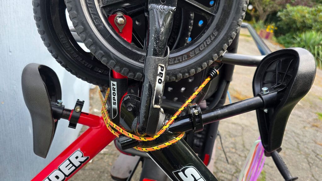 a view of the strider balance bikes tied to the back of a large bike