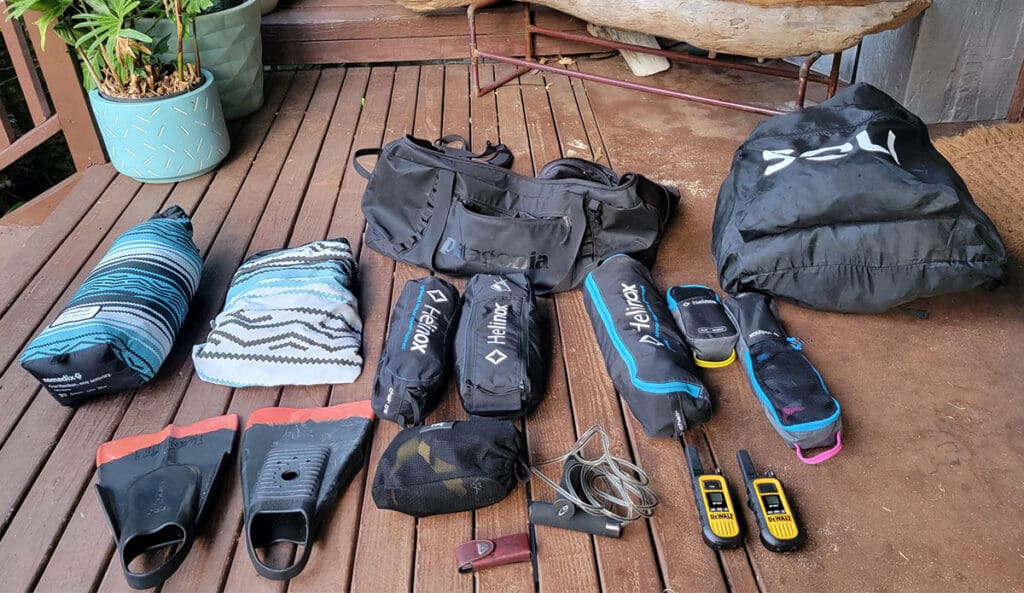 a collection of items for the beach that fit into a duffel bag for travelling.