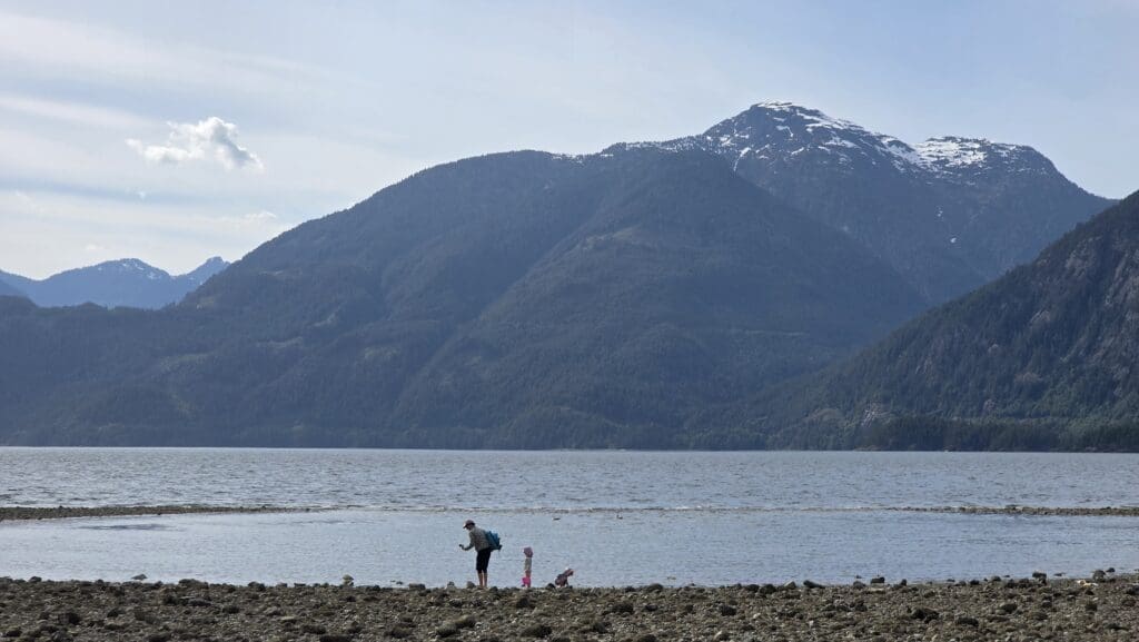 a family explores the beach at low tide at porteau cove provincial park