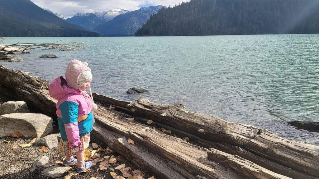 A toddler looks over cheakamus lake in garibaldi provincial park, bc canada