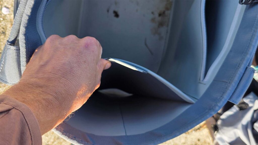 a user looks into their yeti camino bag and opens the side pocket for demonstration.