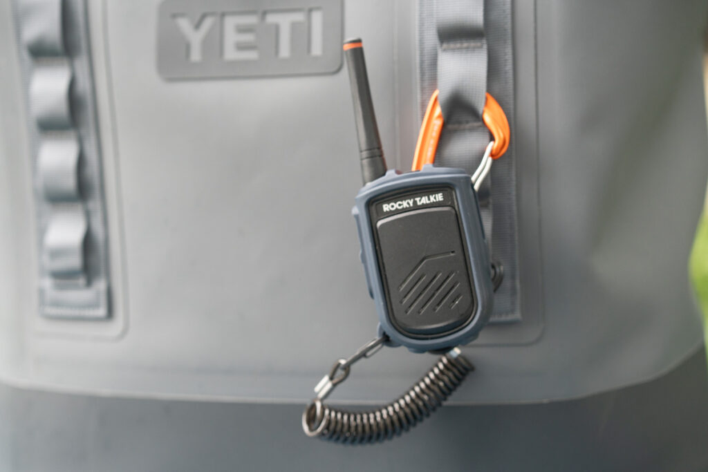 a rocky talkie radio attached to the outside of the yeti camino carryall beach tote