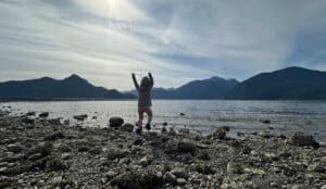 a child throws rocks into howe sound in british columbia at porteau cove provincial park