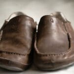 a pair of olukai moloa displayed on a couch cushion