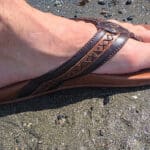 a mans foot inside teh leather flip flops by olukai and new heights